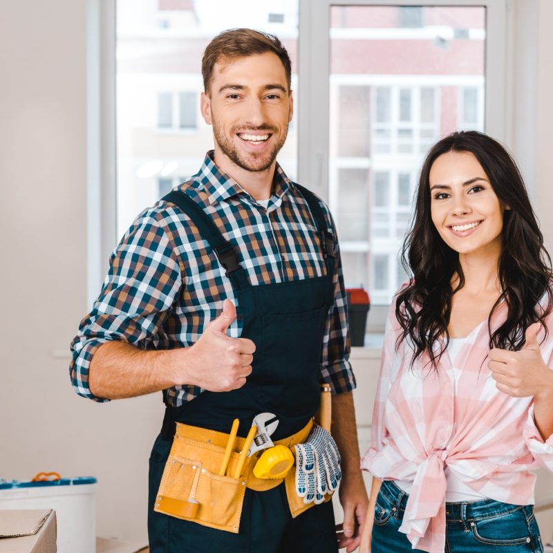 woman and handsome handyman showing thumbs up